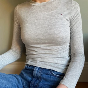 Tommy Hilfiger - Säljer denna fina tröja ifrån Tommy himfiger, formar sig supersnyggt runt kroppen men tyvärr har den blivit för liten för mig:( den är glittrig som man bl.a. ser på bild tre men man ser det tyvärr inte så mycket på resten av bilderna!