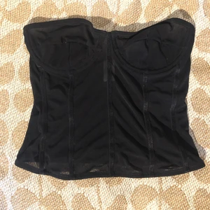  Korset i svart NAKD - Helt ny Genomskinlig svart korsett från NAKD, glömt storleken men skulle gissa på 34. Säljer för att kupporna är för små för mig. Köparen står frakten. Skriv om ni vill ha fler bilder, den ser fett dammigt ut här. 