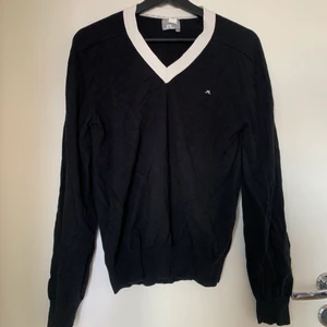 J. Lindeberg tröja, i strl M - Svart J. Lindeberg tunn tröja med vit v-ringad krage, i strl M. Väldigt fin, använt enstaka gånger men säljer då den e sitter lite för stort. Möts upp i sthlm:)