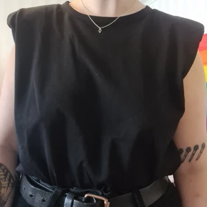 Svart topp med små "axelvaddar" - Svart topp från h&m, köpt för 99kr och säljer för 50kr. Oanvänd förutom för bilden!