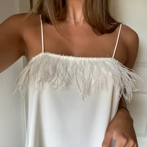 Fjäder topp - Säljer detta fina linne från Zara med fjäderdetajer. Köpt för några år sedan. Storlek M men passa även XS och S.