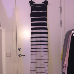 Randig klänning med sido-slits - En svart vit randig klänning med slits på sidorna i storlek L/XL men passar nog mindre storlekar. Klänningen är helt ny och har utmärkt kvalitet. !köparen står för frakten!