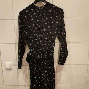 Svart, blommig klänning - Svart blommig klänning från H&M i storlek 40. Använd 1 gång 🌸🖤 