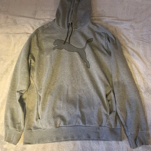 Grå Puma hoodie - Grå puma hoodie i bra skick. Hoodien är ganska lös så man kan säker ha på sig den om man har storlek L. Har tagit plaggets mått så om ni vill ha det så är det bara fråga