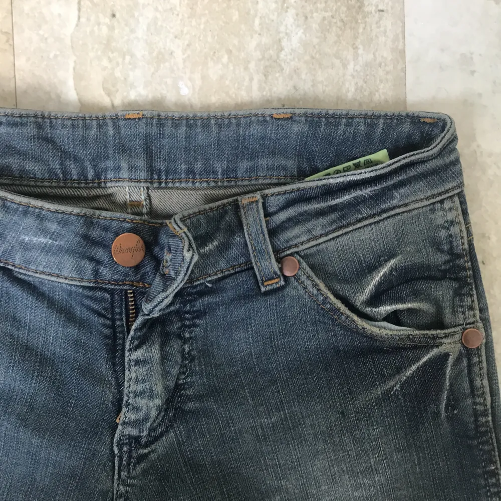 Ett par riktigt snygga jeans från märket Wrangler. Jeansen är super low wasit Bootcut. Säljer dessa på grund av att dom tyvärr inte passar mig. Cola detaljer med storleken W24-L32. Innebenslängden är 83 cm och midjemåttet är 74 cm. Hör av er för mer bilder och frågor. . Jeans & Byxor.