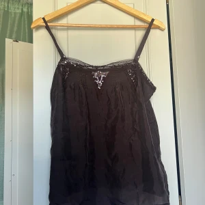 Brunt linne från Couleurs d'été - Ett brunt linne från Couleurs d’été med spets och prälor. Storlek ukänd men uppskattas till en stor s eller medium. Knappt använt med inga defekter.