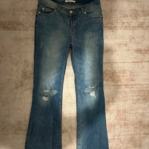Blå Lågmidjade jeans med slitningar - As coola blå jeans med hål på knäna. Dom är Lågmidjade och sitter jätte fint! 