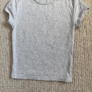 Grå ribbad t-shirt från Bershka - En gullig grå ribbad tshirt från Bershka, använt några gånger. Ett perfekt basplagg till våren och sommaren 🩷🩷