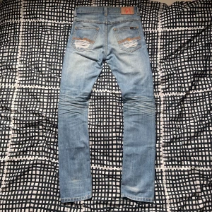 Sällsynta Nudie Jeans! 🤩🦾 - Skitsnygga ljusblå jeans ifrån nudie. De har en helt sjuk tvätt på sig med några slitningar där bak. Dessa är storlek W30 men jag skulle säga att de passar som W28-W29 mer. Dessa har inte någon längdstorlek men jag har L34 och dessa passar mig riktigt bra. De har en slim till normal passform och en midwaist skulle jag själv säga. Modell: 185cm 62kg, Perfekt för sommaren. Kom med prisförslag och tveka inte om du har någon fråga!🦾🦾