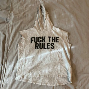 Ärmlös hoodie - Säljer en grå ärmlös hoodie från Sally&Circle med texten 'FUCK THE RULES' tryckt i svart på framsidan. Jag tvättar alltid plaggen innan jag postar dom. Skriv om du har frågor o läs helst min bio innan du köper✨