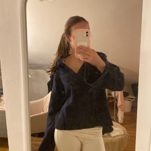 Mörkblå stickad tröja - Säljer en super fin mörk blå stickad tröja med en v-ringad design och krage. Tröjan har långa ärmar med slit. Från gina tricot , storleken står inte men skulle gissa på S och skulle nog passa M också!