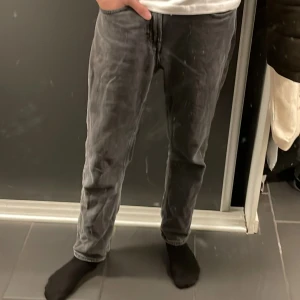Grå jeans från Dressmann - Snygga grå jeans från Dressmann i en klassisk straight fit. Perfekta för en stilren look. De har en normal passform och är tillverkade i ett slitstarkt material.
