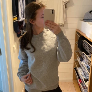 Grå sweatshirt från Gina Tricot - Säljer en stilren grå sweatshirt från Gina Tricot. Tröjan har en klassisk rund hals och långa ärmar med ribbade muddar. Perfekt för en avslappnad look. Hör av dig vid intresse! 😊