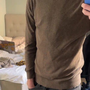 Brun polo tröja i slim fit - Säljer en stilren brun polo tröja i slim fit. Tröjan har långa ärmar och är perfekt för en snygg och enkel look. Passar bra till jeans eller chinos och sena utekvällar/ middag.