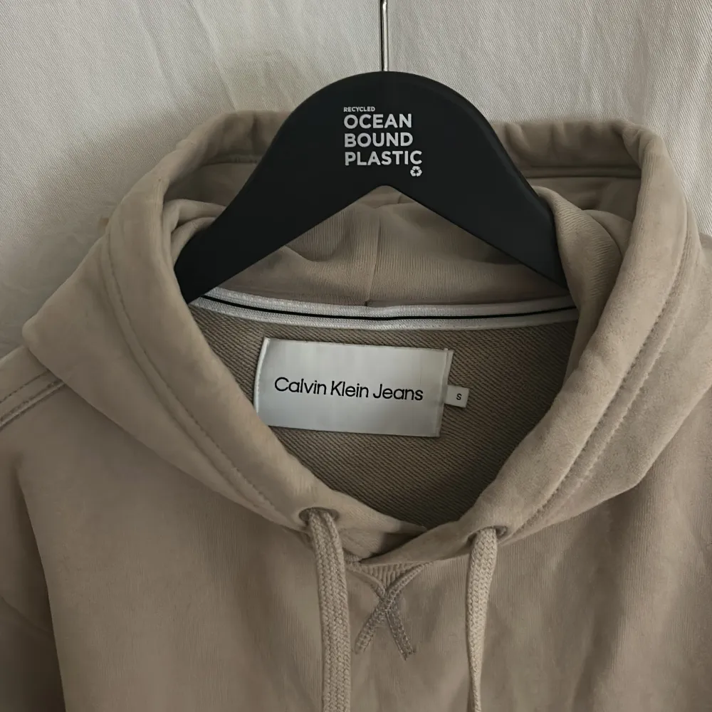 Säljer beige hoodie från Calvin Klein Jeans. Hoodien är inte använd och ha inga defekter. Ny pris ligger på runt 1000kr. Sitter ett svart loga på armen och en rymlig fram ficka. Hör av dig om du har några frågor MVH . Neuletakit & Villapaidat.