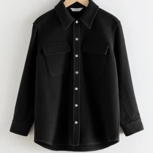 Svart overshirt i ull från & other stories - Snygg svart overshirt med knappar och två stora bröstfickor. Använd men i jättebra skick, inga defekter förutom lite nopprig på ett ställe (se sista bilden), syns inte mycket och går säkert att få bort. Nypris 1300.