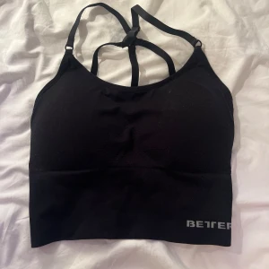 Svart sporttopp från Better Bodies - Säljer en svart sporttopp från Better Bodies med smala axelband och korsad ryggdesign. Perfekt för träning med sin stretchiga passform och bekväma material. Kanske lite liten i sin storlek men ändå stretchig.