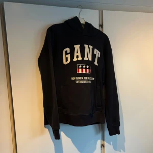 Marinblå hoodie från GANT - Säljer en marinblå  hoodie från GANT, som är i nyskick då jag knappt har använt den 