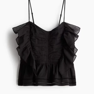 HM Svart volangtopp  - Snygg svart topp med volanger och tunna axelband. Helt slutsåld på hemsidan, är i nyskick med lappen kvar och i storlek S💕Säljer då jag råkade köpa två. Hör av er för fler frågor!