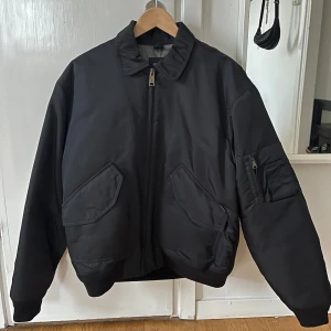 Svart bomberjacka från Carhartt - Säljer min svarta bomberjacka från Carhartt. Jackan har en ficka med dragkedja på ena armen och två fickor med knappar på framsidan. Den är endast använd 4 gånger och är i princip i nyskick. Nypris 3145 kr. Jackan har även utgått ur sortimentet. Kvitto finns!