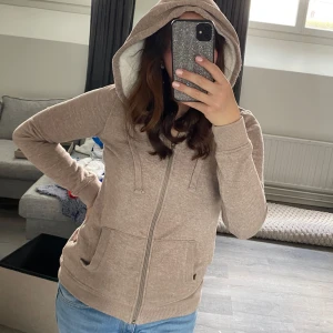 Beige hoodie med dragkedja - Säljer en mysig beige hoodie med dragkedja och fickor framtill. 
