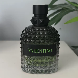 Valentino Uomo Born in Roma Green Stravaganza - Upptäck Valentino Uomo Born in Roma Green Stravaganza, en elegant herrparfym i en stilren flaska med ett unikt mönster. Den svarta flaskan har en grön logotyp och en sofistikerad design som utstrålar lyx. Perfekt för den som vill ha en doft med karaktär och stil.