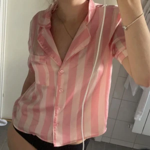 Victoria Secret-Liknande Pijamas topp  - Säljer en söt rosa randig natt-blus med korta ärmar och knappar framtill. Den ger victoria secret 2000s vibes 🥰 