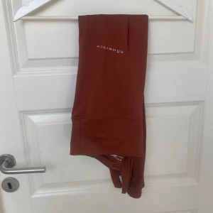 Löpar tights från Röhnisch - Snygga rostbruna leggings från Röhnisch med diskret logga på benet. De är tighta och stretchiga, perfekta för löpning. Materialet känns mjukt och följsamt mot huden och det är en ficka i midjebandet bak:)