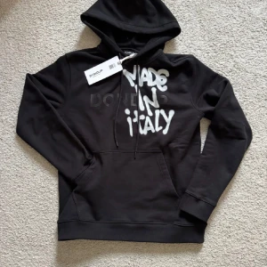 Dondup Hoodie - Svart hoodie från Dondup med vit graffiti-inspirerad text 'MADE IN ITALY' Superbra Cond, JÄTTE ovanlig att få tag på, väldigt limiterad. Den ända på marknaden med storlek S. Hör av er vid minsta lilla fråga! Mvh LH