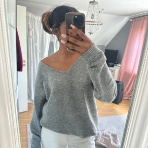 Grå stickad tröja  - Mysig grå stickad tröja från 157 med v-ringning och avslappnad passform. Tröjan har långa ärmar och kan bäras offshoulder. Superskön! Storlek M men passar mig som vanligtvis har S