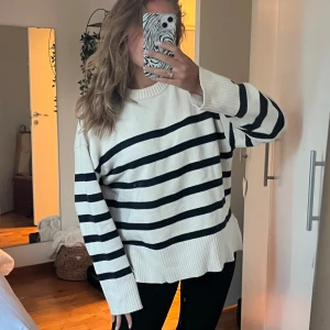 Randig oversized tröja  - Säljer en vit och svart/mörklblå randig tröja med oversized passform och långa ärmar. Tröjan har bred ribbad mudd vid ärmslut och nederkant samt en klassisk rund halsringning. 