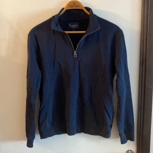 Marinblå half zip-tröja Bondelid - Snygg marinblå långärmad tröja från Bondelid med half zip-dragkedja i halsen. Klassisk och stilren modell i mjuk bomull, perfekt för lager-på-lager. Passar dig som gillar enkel och clean stil.
