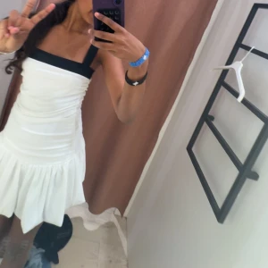 Vit kort klänning med svarta band - Prislappen kvar! Gina tricot 14+Supersöt vit kortklänning med breda svarta band. Storlek S  men passar mig som är XS köptes för 399 på Ginatricot 14+