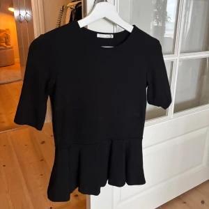 Svart topp med volang från Zara - Svart topp från Zara med volang nertill. Endast använd 2ggr. Storlek S 