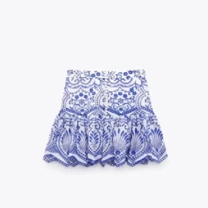 Vit och blå volangkjol med mönster - Supersöt kort kjol i vitt och blått med detaljerat mönster och volangkant. Perfekt för dig som vill sticka ut med en fräsch och somrig vibe. Knappt använd!🤍 