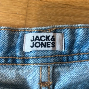 Ljusblå jeans från Jack & Jones - Säljer ett par klassiska ljusblå jeans från Jack & Jones. Jeansen har raka ben, fem fickor och snygga kontrastsömmar. Perfekt basic i garderoben med normal passform och bälteshällor. Tillverkade i slitstarkt denimtyg. Helt nya har provat en gång.