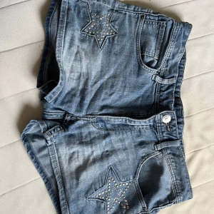 Jeansshorts med stjärndetaljer - Snygga blå jeansshorts med stjärnor dekorerade med små nitar både fram och bak. Dem är midwaist!