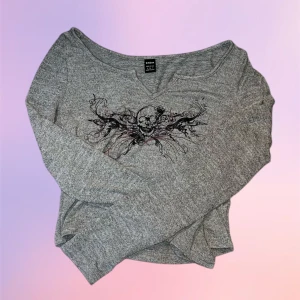 Lång ärmad tröja - En långärmad tröja med coolt tryck! Tyget är mycket mjukt och har inga defekter alls . Tröjan är gråbeige, croppad med en v-ringning.