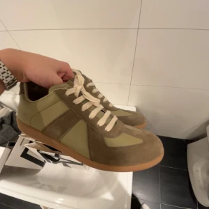 Beige och bruna sneakers med mockadetaljer - Snygga sneakers i beige och brunt med ovandel i mocka och syntet. Skorna har rund tå, platt sula och klassisk snörning. Perfekta för en avslappnad stil och passar till många outfits.