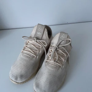 Beige Adidas Pharrell Williams sneakers - Säljer ett par beigea Adidas Pharrell Williams sneakers, köpta för 1000, bra skick förutom att dom är lite fläckiga. Pris går att diskuteras.