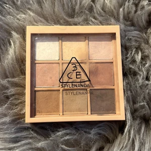 3CE ögonskuggspalett med neutrala toner - En snygg ögonskuggspalett från 3CE Stylenanda med nio olika nyanser i beige, brunt och guld. Perfekt för att skapa både naturliga och mer markerade ögonlooks. Kommer i en fyrkantig förpackning med genomskinligt lock.
