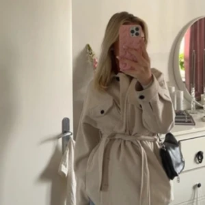Beige kappa - Säljer en beige kappa som är köpt från Nelly. Perfekt för lager-på-lager och enkel att styla till olika outfits. 