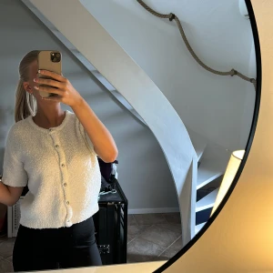 Stickad kofta  - Säljer en söt vit kofta med korta ärmar och pärlknappar framtill då den inte kommer till användning!