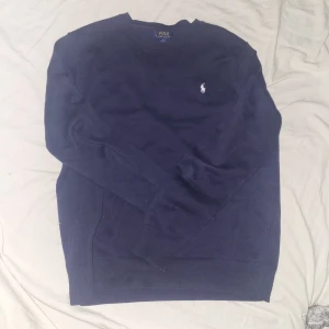 Mörkblå tröja från Polo Ralph Lauren - Säljer en klassisk mörkblå tröja från Polo Ralph Lauren. Har nästan aldrig använt tröjan så den är praktiskt taget i nytt skick. Tveka inte att höra av dig vid minsta fundering🙌 (OBS: tröjan är i S)