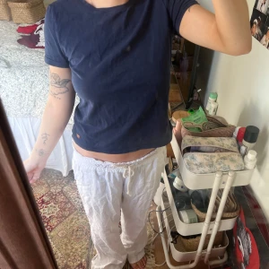 Mörkblå croppad t-shirt i st S - En enkel och stilren mörkblå croppad t-shirt med rund halsringning. T-shirten har korta ärmar och en normal passform. Perfekt för en avslappnad look.