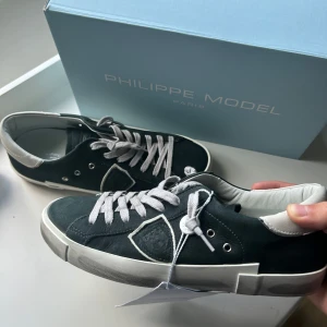 Philippe Model sneakers nya - Snygga svarta Philippe Model sneakers med vita snören och vit sula. Skorna är helt nya/oanvänga med taggen på. Box inkluderas. Säg till om ni har frågor!