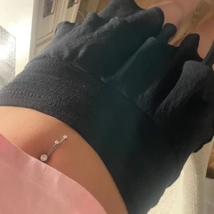 Svart volangkjol - Säljer en svart kortkjol med volangdetaljer. Kjolen har en bred midjeresår och är tillverkad i ett lätt, flowy material som ger en snygg siluett. Perfekt för dig som vill ha en trendig och bekväm kjol till sommaren.