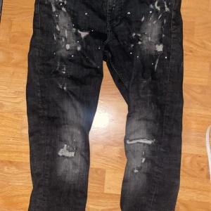 Svarta jeans med slitningar och färgstänk - Säljer mina supply demand jeans för de är lite stora för mig orkar inte spänna bältet för hårt det här är den gamla modellen lite svårt att hitta men är bra som ny  använd typ 4-6 gånger. FAST PRIS