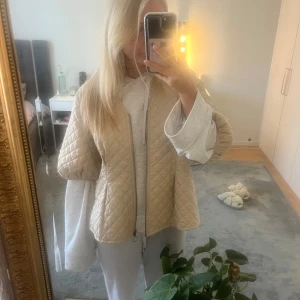 Beige quiltad väst med dragkedja - Säljer en beige quiltad väst med dragkedja framtill. Västen har korta ärmar och ett lätt vadderat material som ger en trendig look. Perfekt att slänga över en hoodie eller tröja för extra stil💕