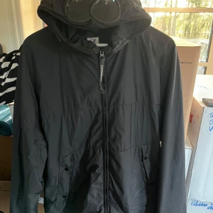 Cp company glasögon jacka  - Jag säljer min CP company jacka pågrund utav att den blivit för stor på mig, den är i storlek L men är lite stor i storleken, passar perfekt nu till våren och början av sommaren, den är vattentät. Alla lappar finns kvar till jackan och fler bilder kan fås vid förfrågan. Pris kan sänkas vid snabb affär